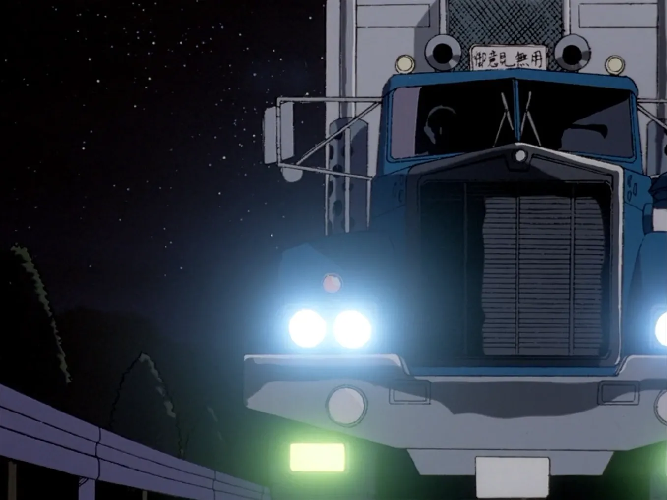 A still from Patlabor: A semi truck from directly ahead, lights bright on a nighttime highway.